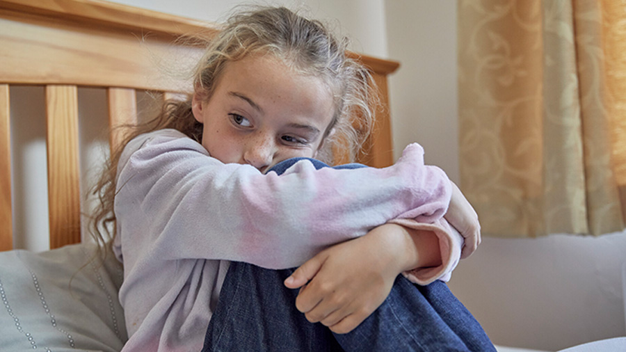 Young girl huddled with her knees up