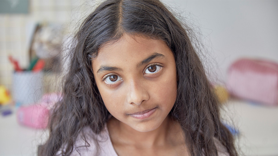 Young girl walking along road, looking over shoulder