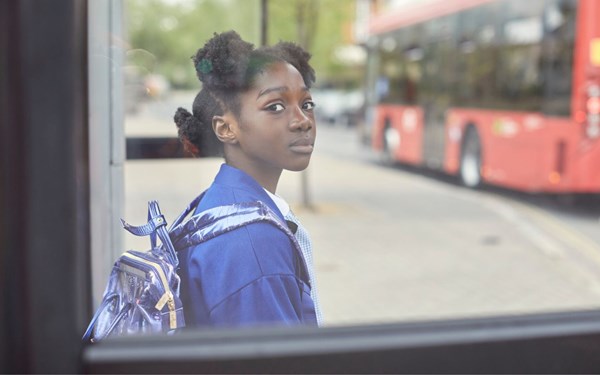 Young teenage girl sitting at a bus stop