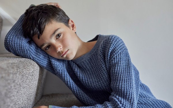 Child sitting on stairs looking worried or sad