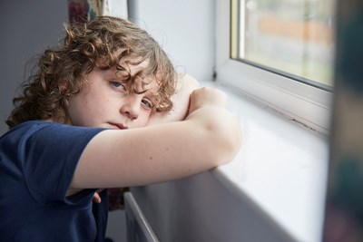 Young boy looking out the window during the coronavirus pandemic lockdown