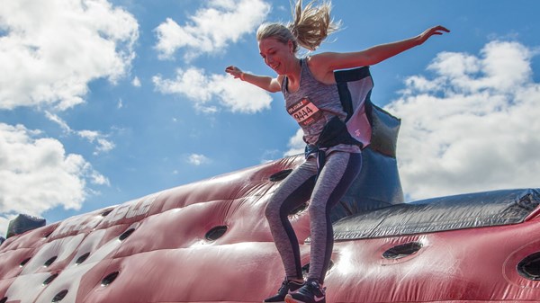 Woman jumping on inflatable obstacle