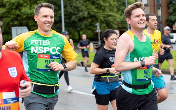 A member of Team NSPCC smiling while taking part in the Great Manchester Run.