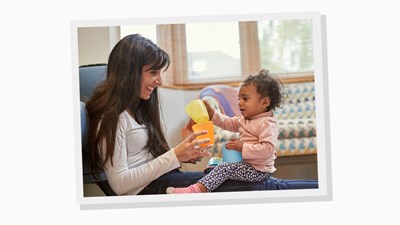 Mum and baby daughter playing with plastic cups.