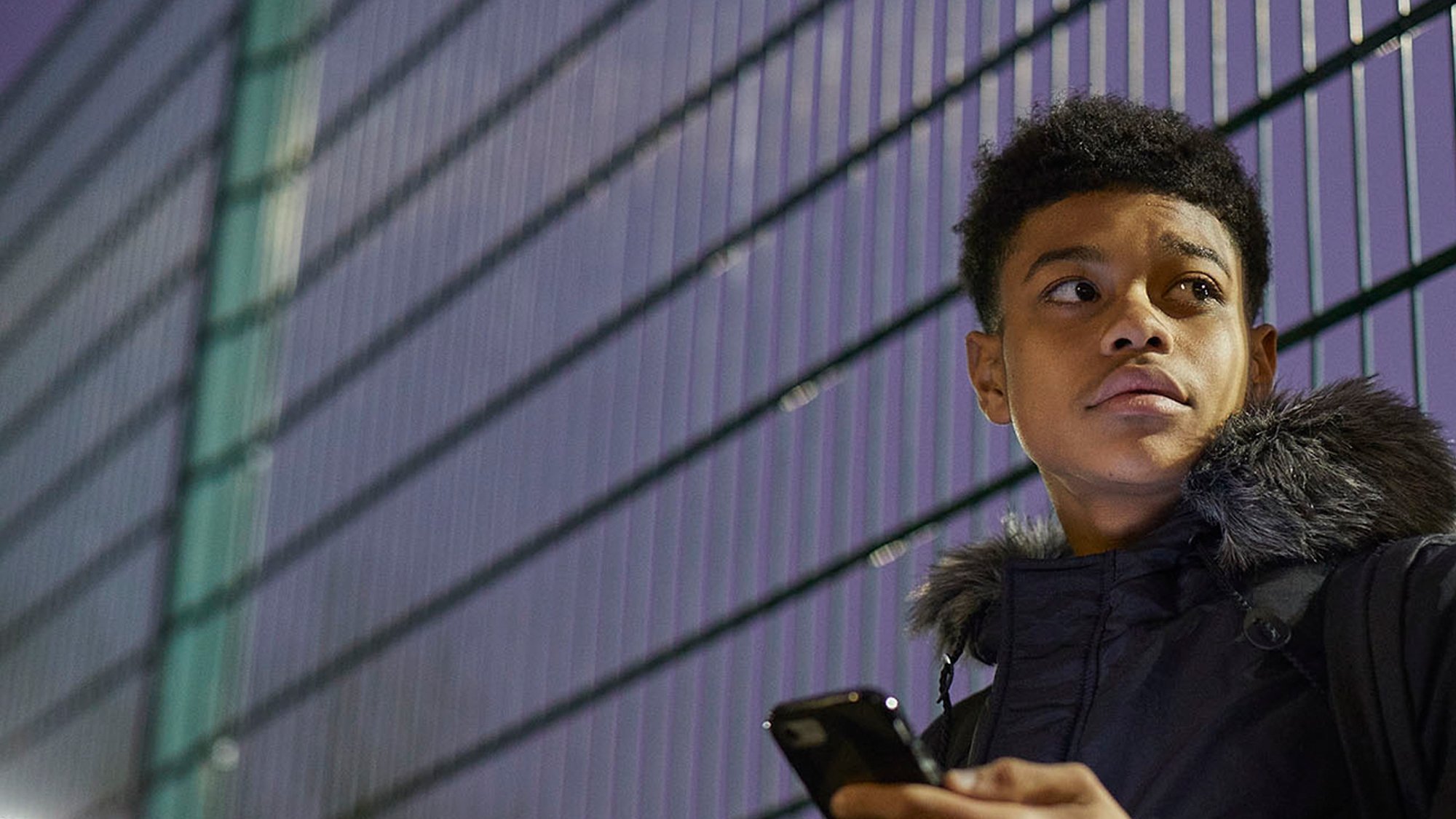 Boy checking his phone outside on the road