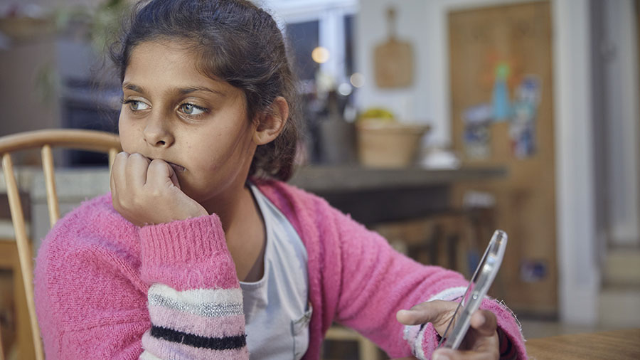 Young girl with mobile phone looking worried