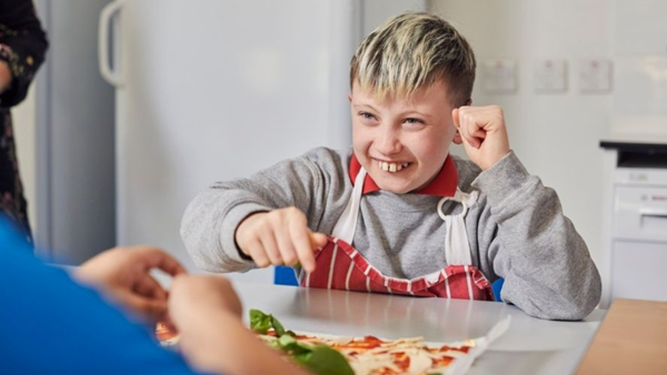 Boy eating and laughing at table