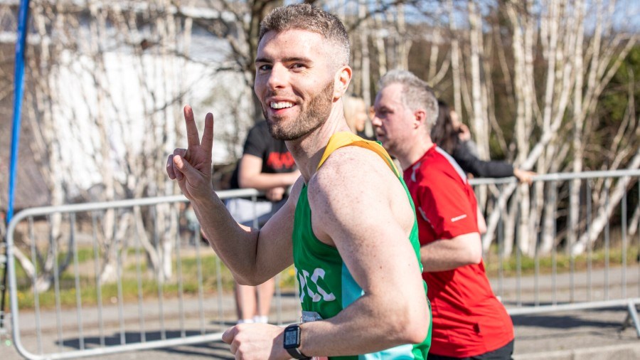 Cardiff Half runner in NSPCC vest, makes V for victory sign