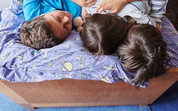 3 brothers napping in bed, sharing their ipad