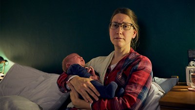 Mother with perinatal mental health issues cradling her baby