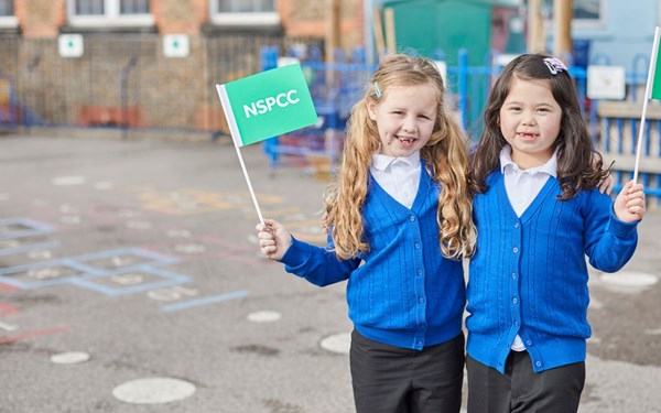 Two children holding NSPCC flags