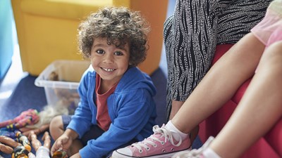 Young boy smiling and playing with toys.