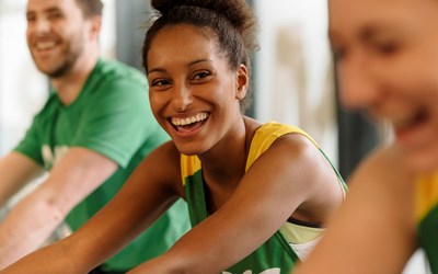 A woman smiling on an exercise bike. 