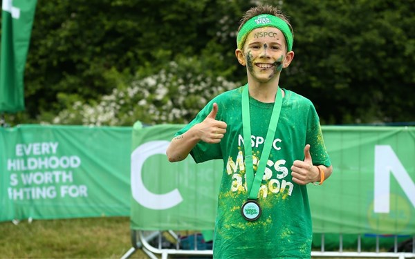 A child holds a medal at the end of mess-athon