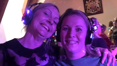Two women wearing headphones at a silent disco