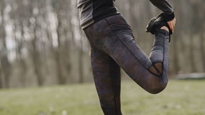 A woman stretching legs in park