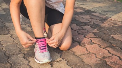 A woman ties the shoelaces on running shoes