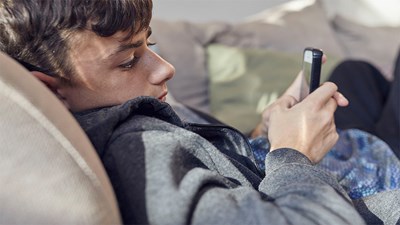 A teenager engrossed in their mobile phone.