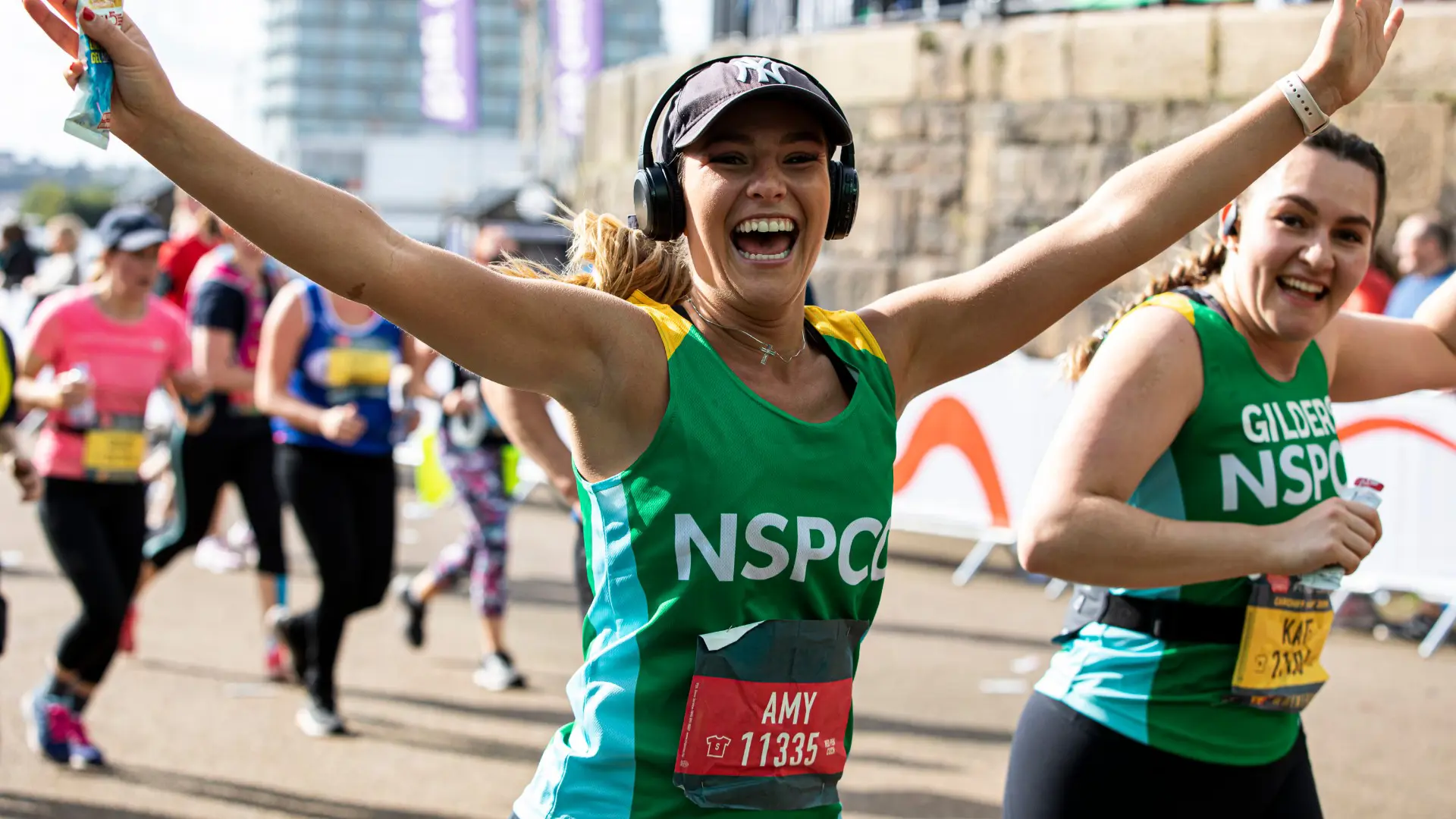 Woman in NSPCC vest running and smiling