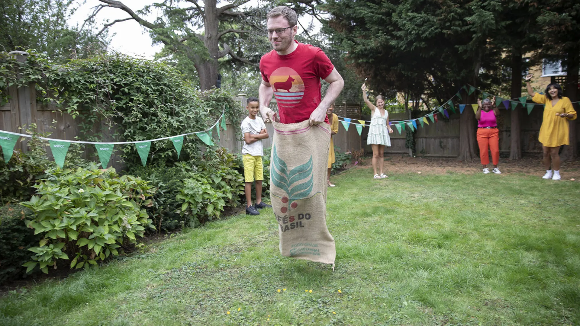 A fundraiser smiling while taking part in a sack race.