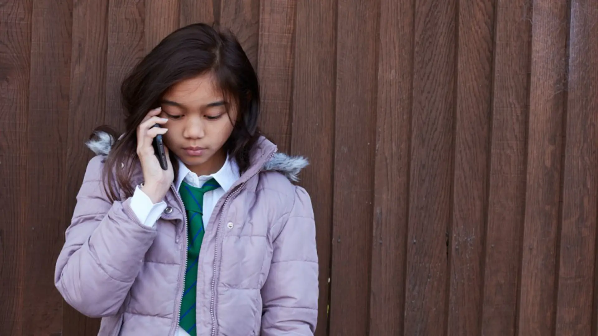 Teenage girl in the street speaking on a mobile phone