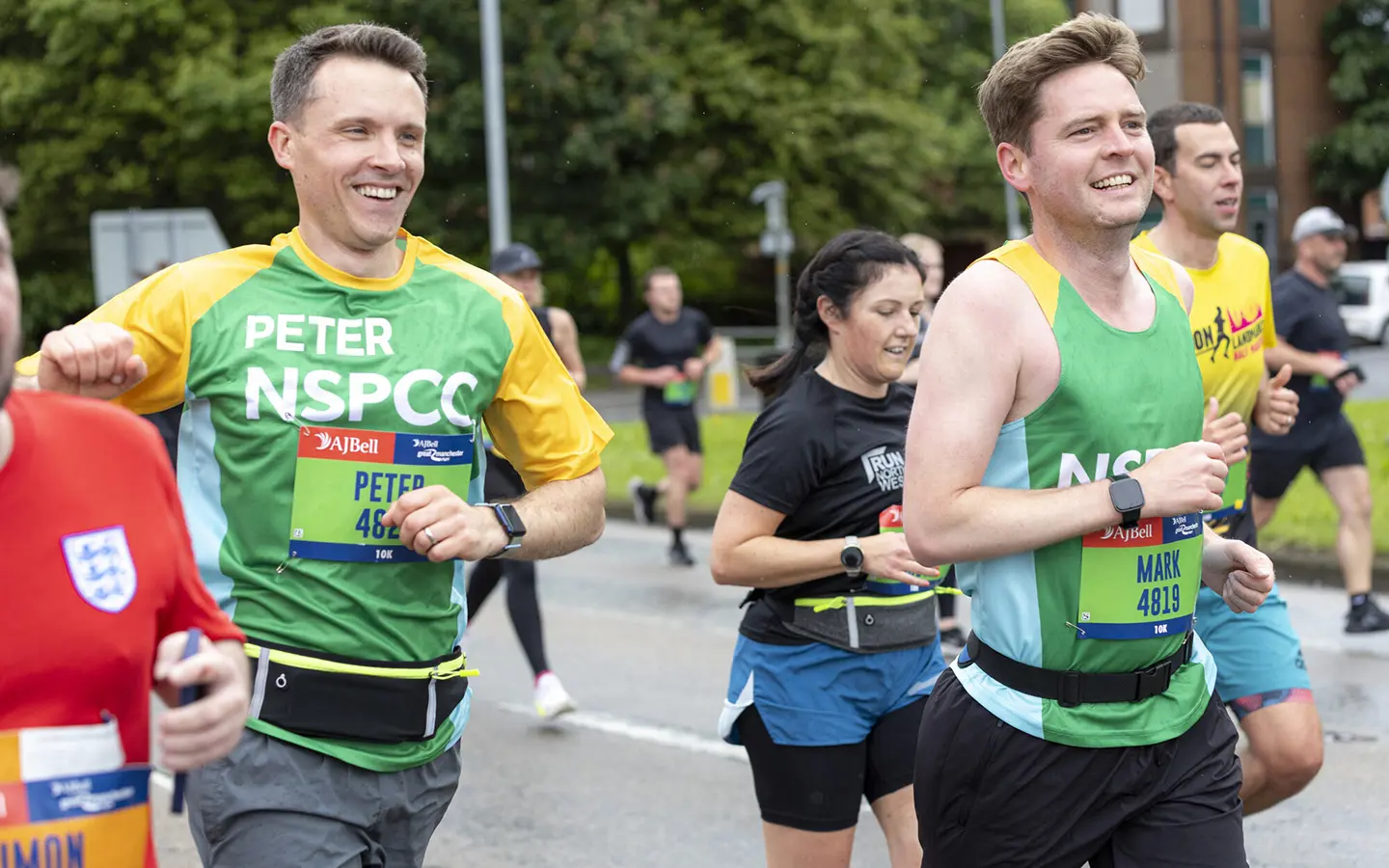 A member of Team NSPCC smiling while taking part in the Great Manchester Run.
