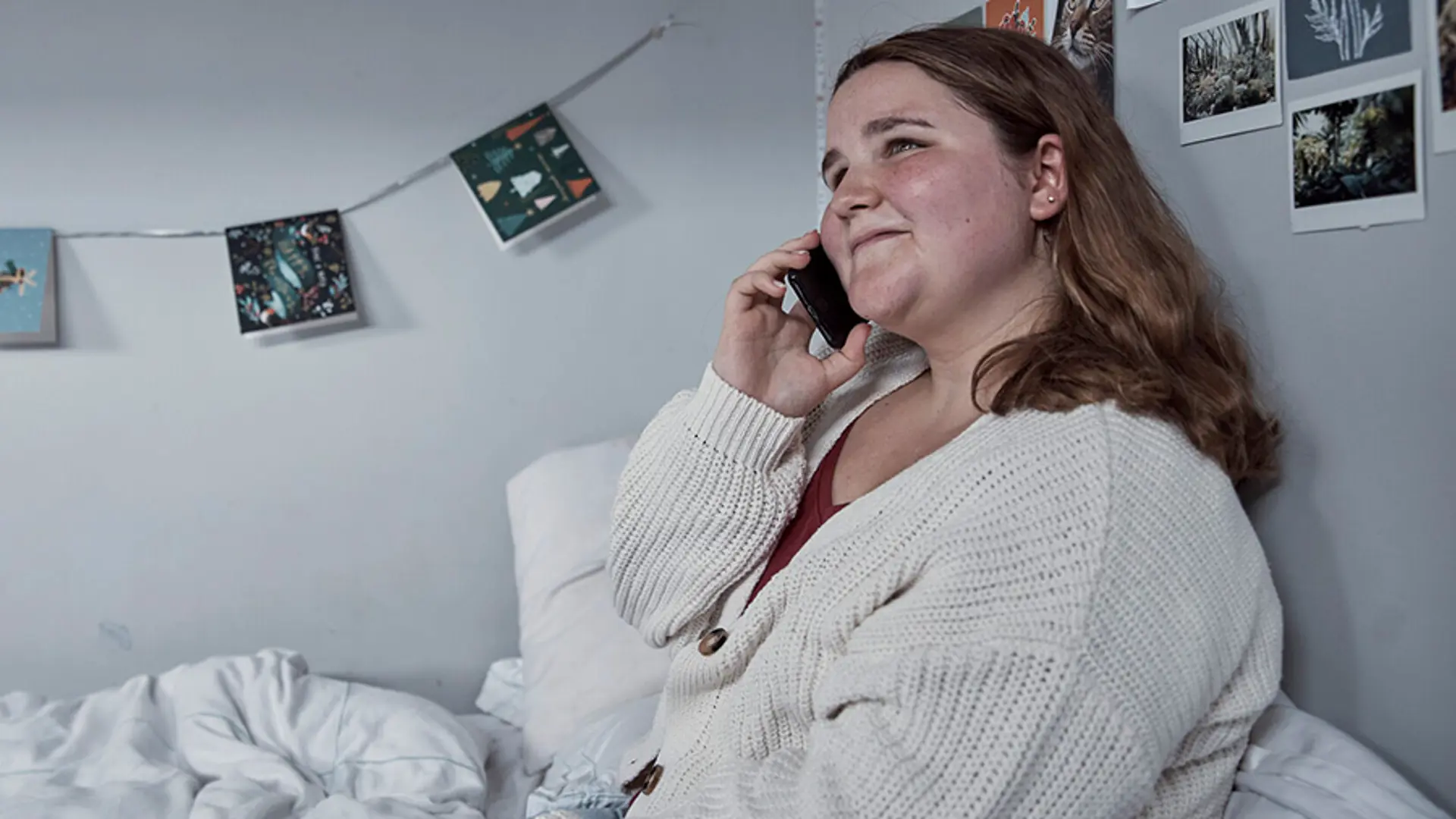 Photograph of a young person making a phone call.