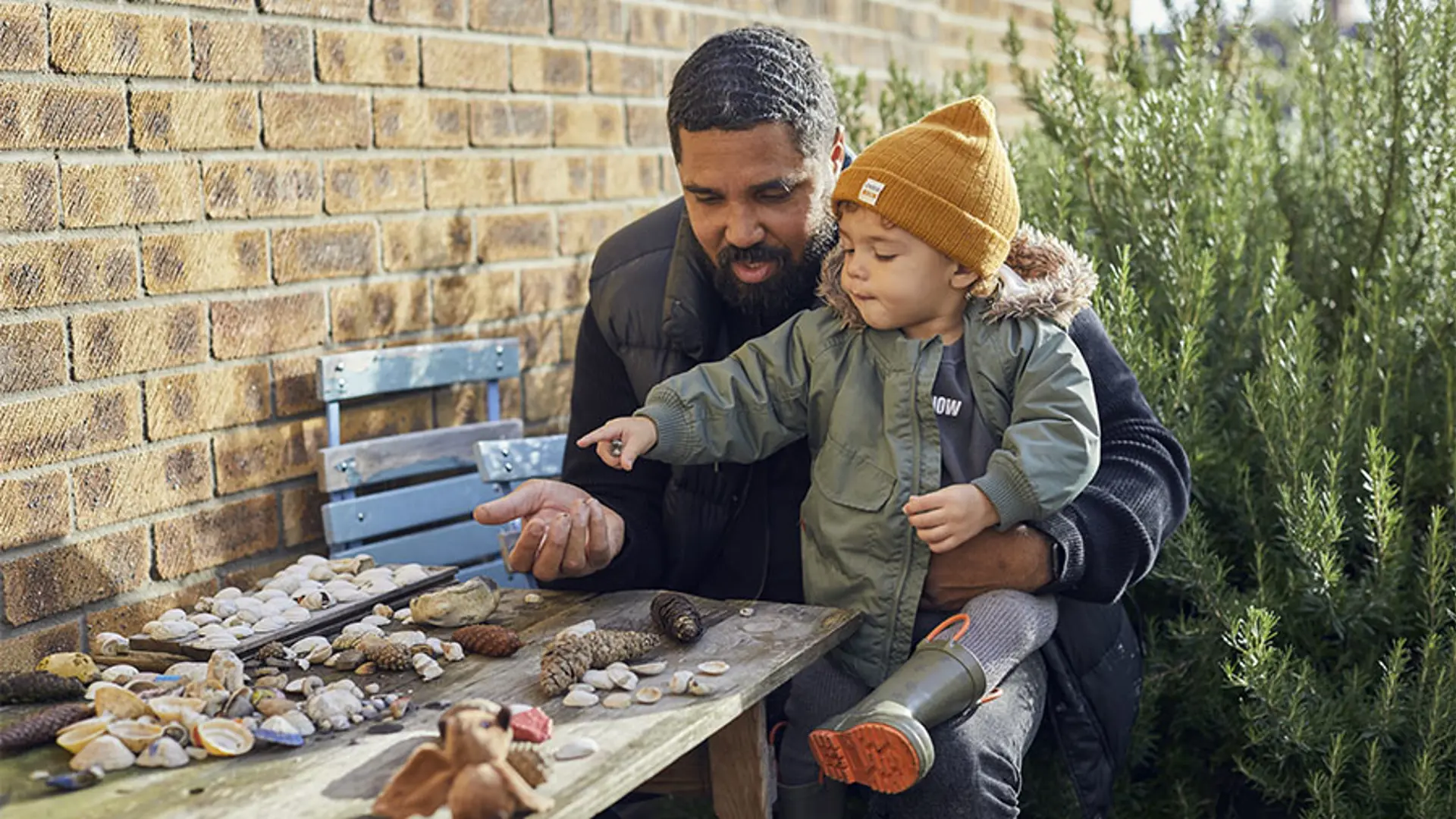 A father playing with his young boy in the garden.