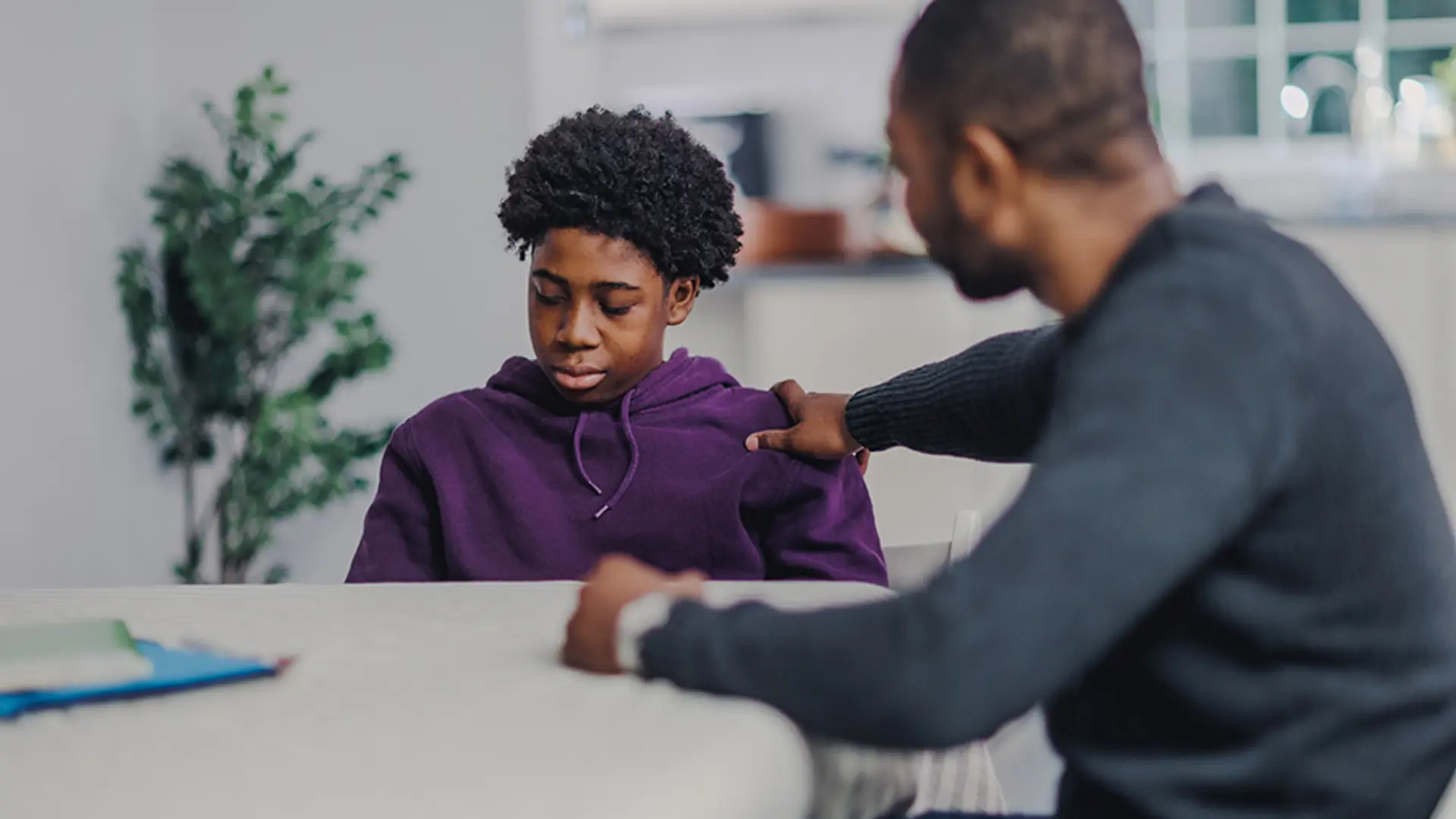 An upset teenager being comforted by a trusted adult.