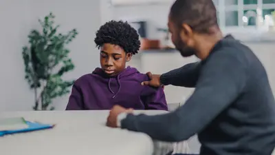An upset teenager being comforted by a trusted adult.