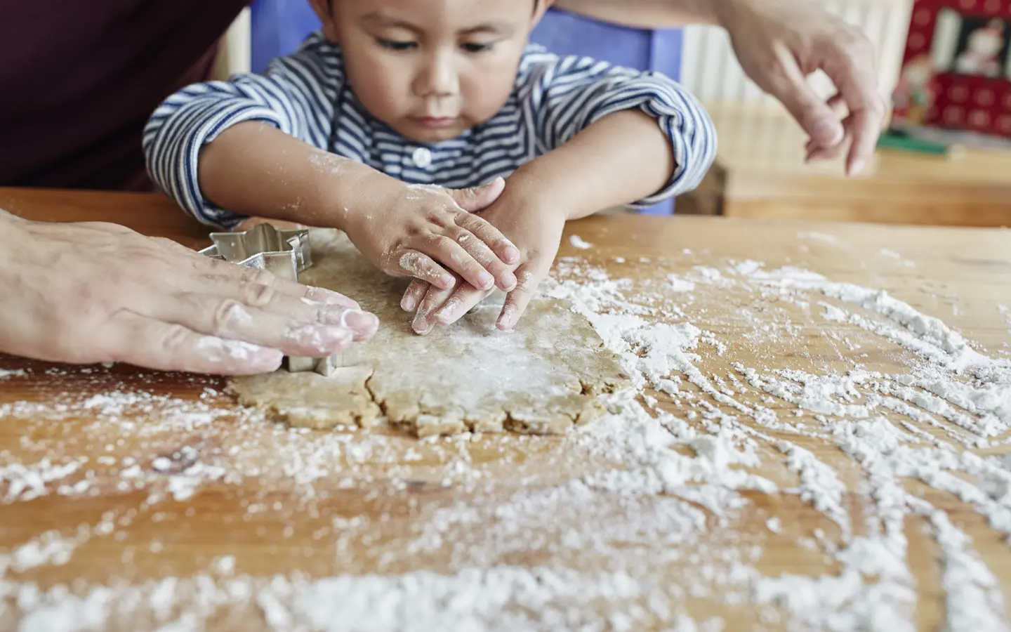 A toddler cutting out gingerbread shapes