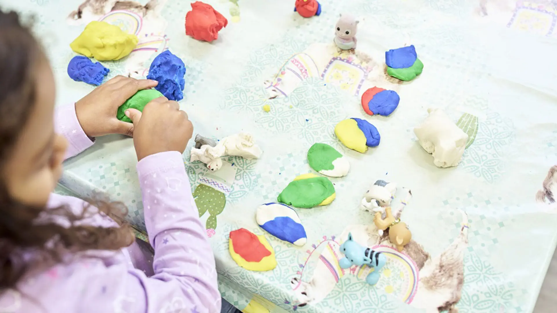 Photograph of a child playing with polymer clay.
