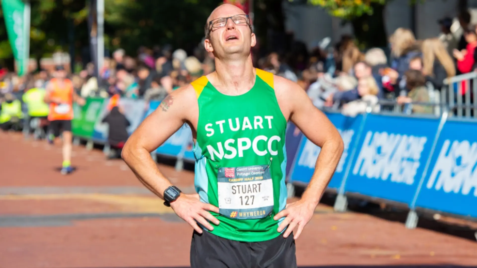 A man stops to catch his breath at the finish line of a half marathon