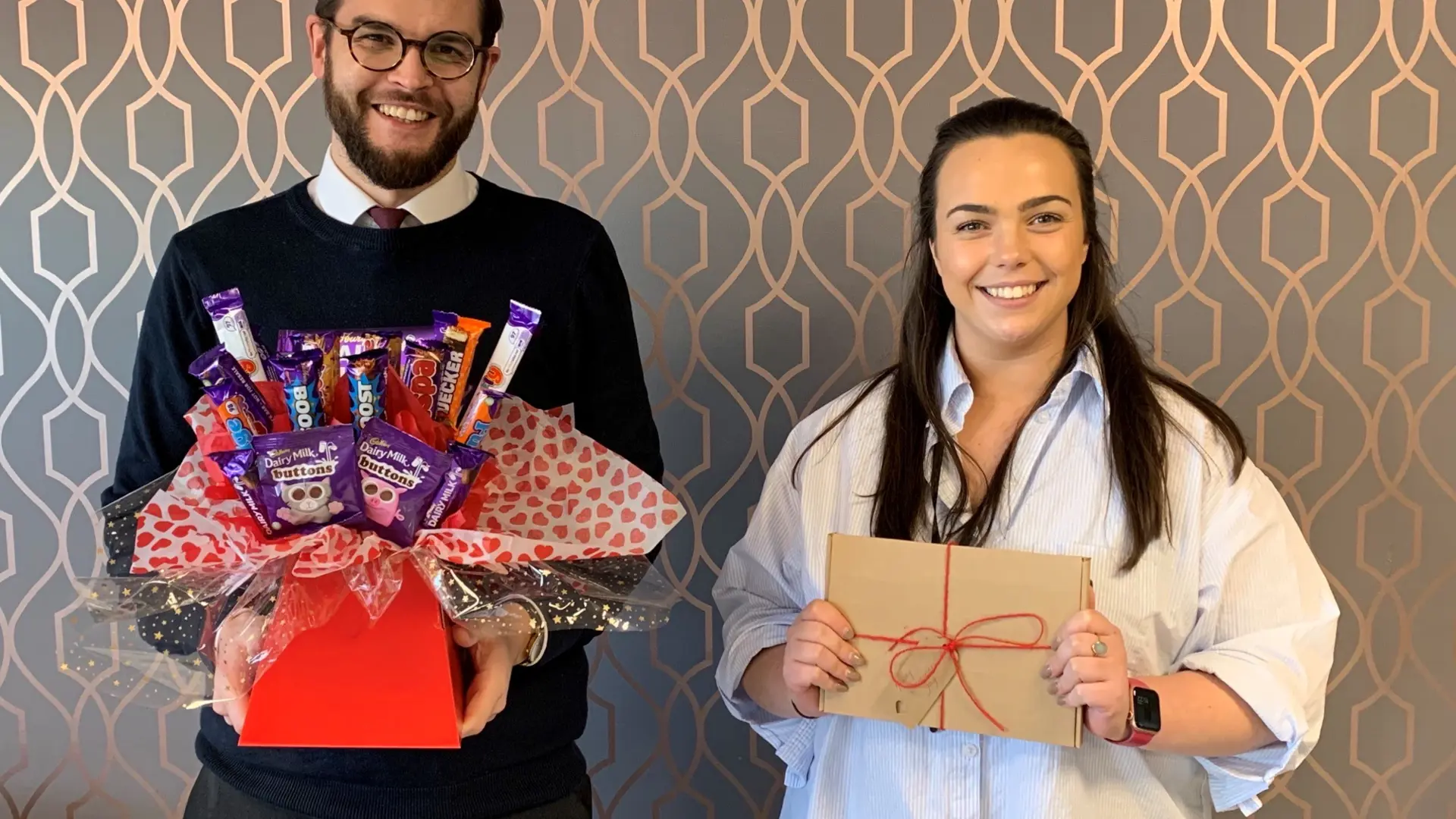 Two Burnetts Solicitors employees holding a charity hamper.