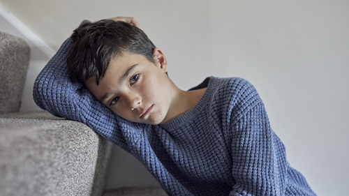 A young child staring blankly into the distance.